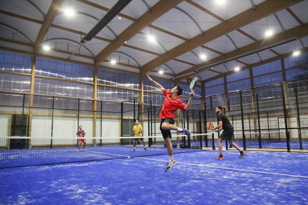 Players rallying on an indoor padel court