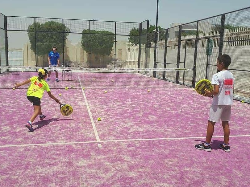 Padel players rallying on a pink outdoor court