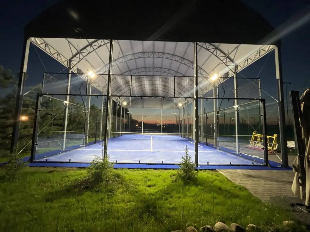 Indoor padel court with fabric roof structure and artificial turf