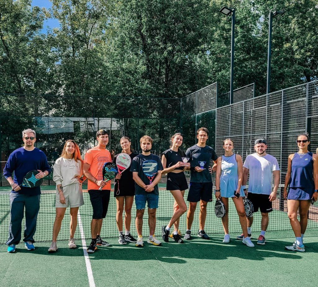 A large group of padel players at an outdoor community court