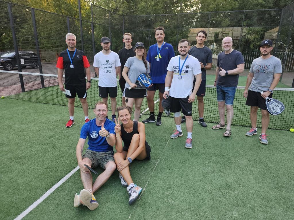 Padel club members relaxing together on a court bench