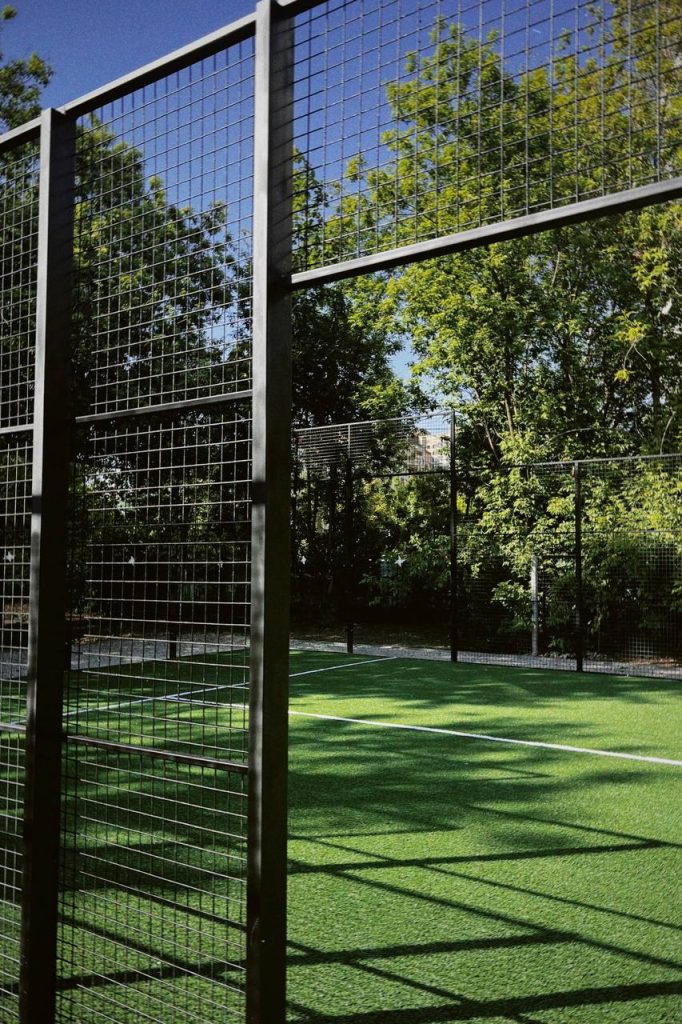 Padel court steel structure with mesh fencing and grass surround