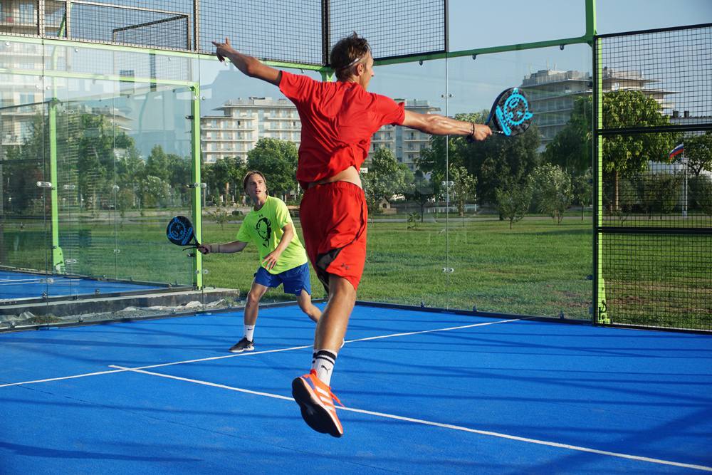 Two players rallying on an outdoor padel court
